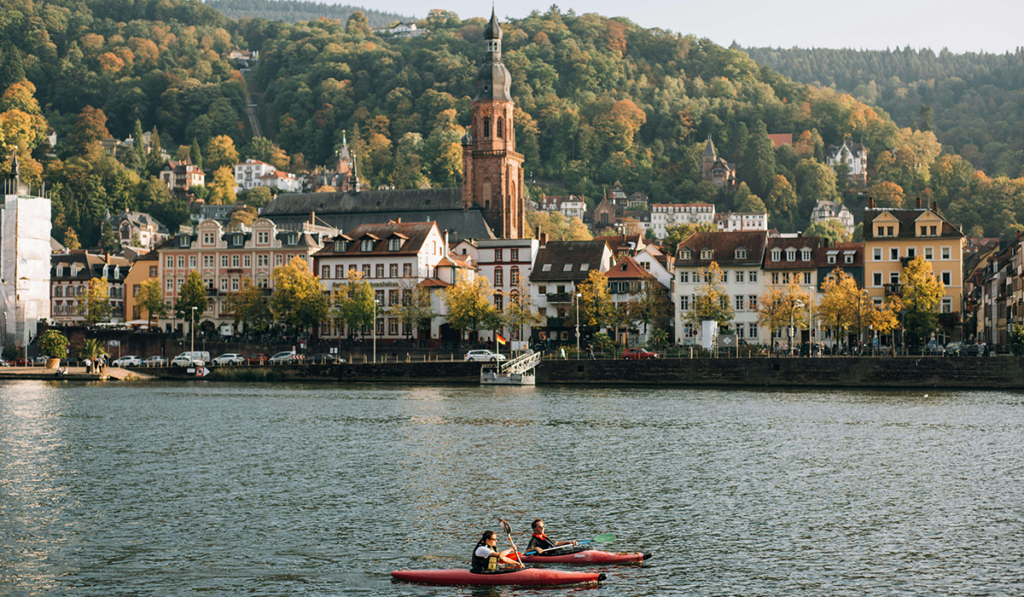 two small boats on river with city in background
