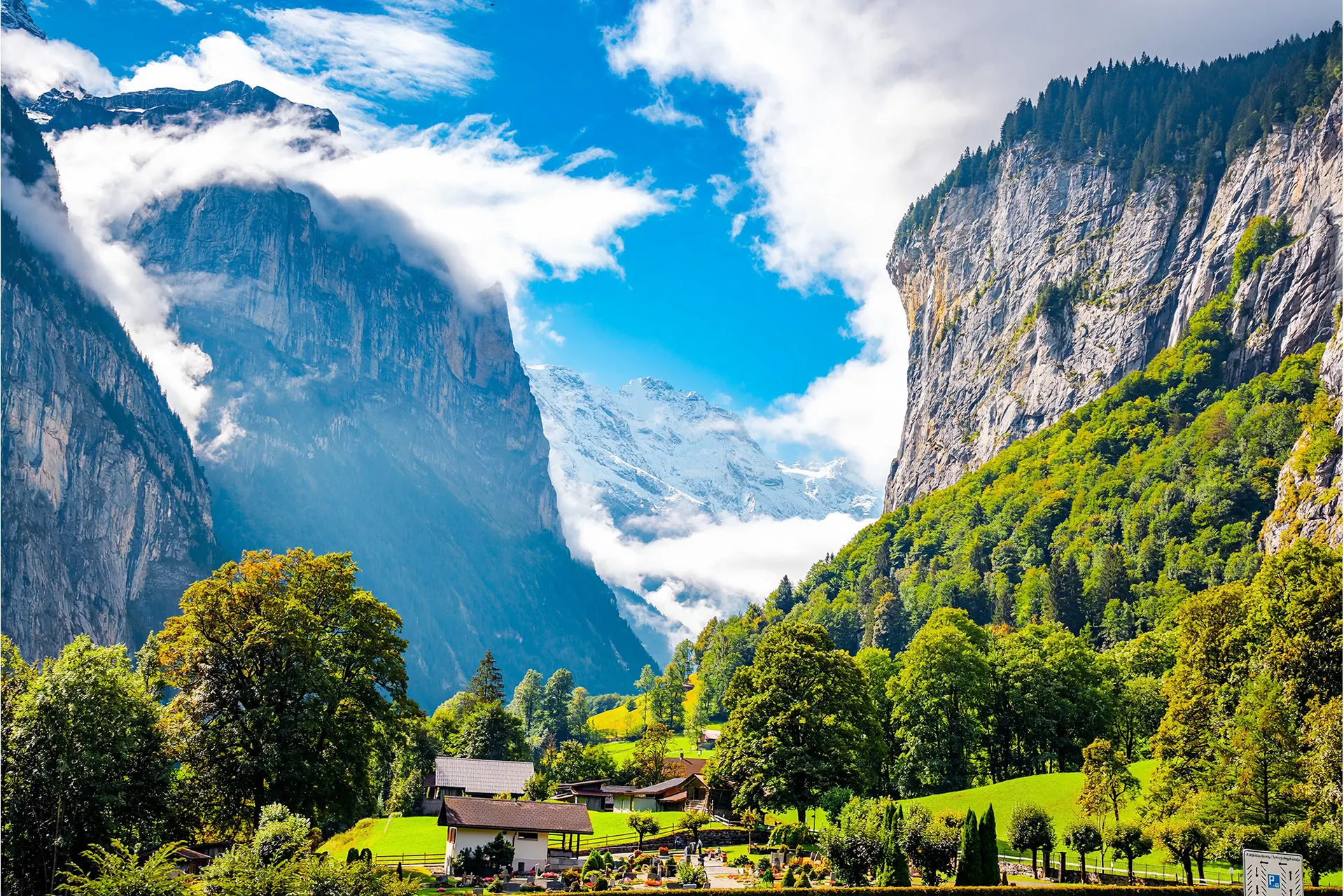 Dramatic landscape of mountains surrounding valley; village at foot of mountains