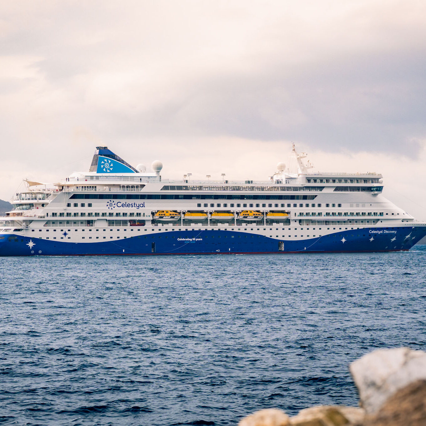 Wideshot of the Celestyal Discovery, docked in the bay of Santorini