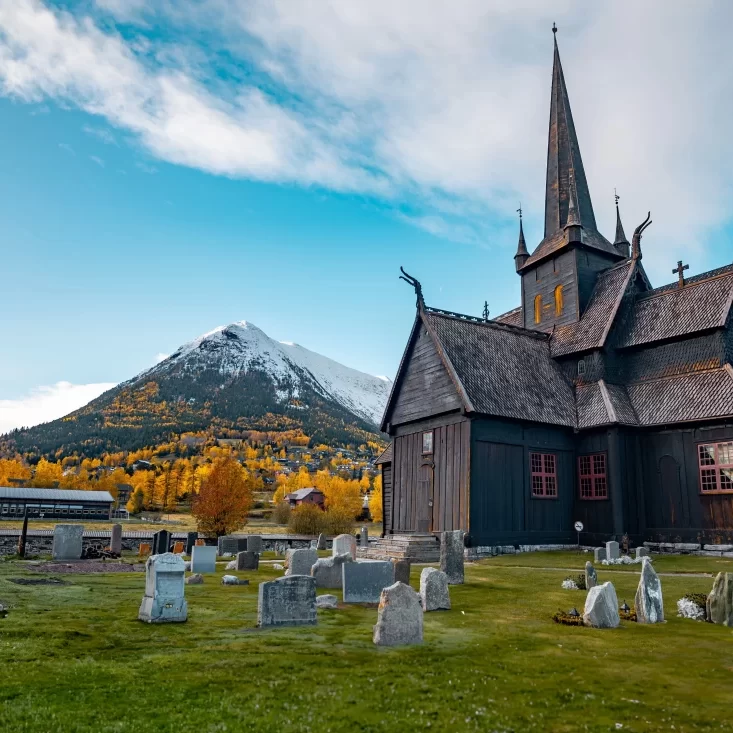 Church next to graveyard and snow-tipped mountain in the distance