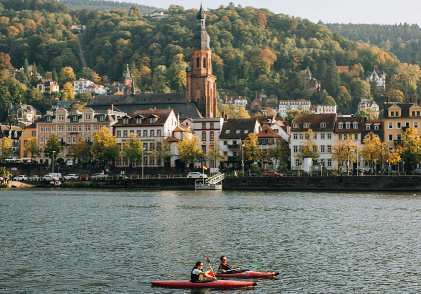 two small boats on river with city in background